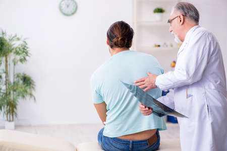 Young back injured man visiting experienced doctor