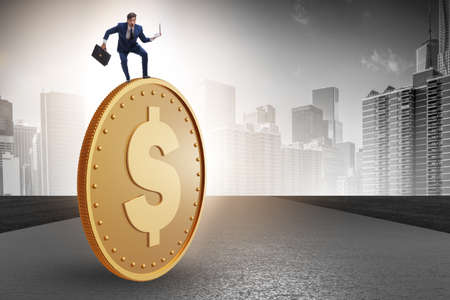 Businessman with giant golden dollar coinの写真素材