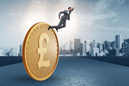 Businessman with giant golden pound coinの写真素材