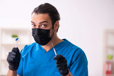 Young male dentist working in the clinicの写真素材