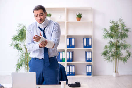 Injured male employee at workplace after accidentの写真素材