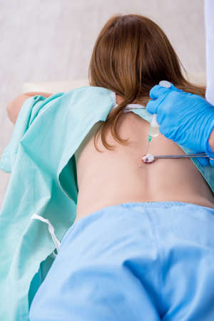 Young back injured woman visiting male doctor chiropractor
