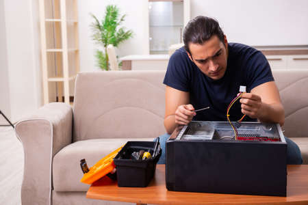 Young man repairing computer at homeの写真素材