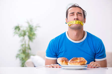 Young hungry man in dieting conceptの写真素材