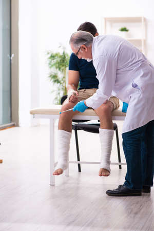Young injured man visiting doctor traumatologistの写真素材