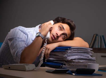 Young financial manager working late at night in officeの写真素材