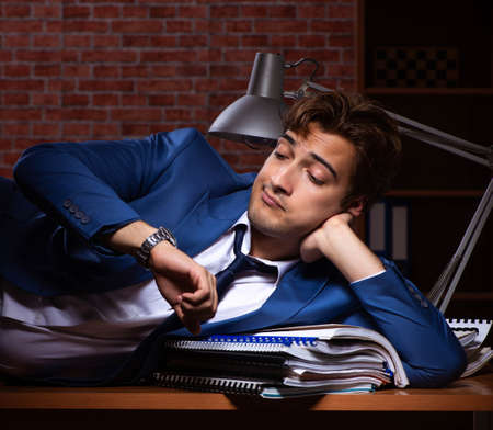 Young businessman working in the office at nightの写真素材