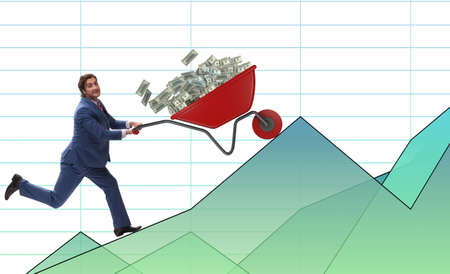 Businessman pushing wheelbarrow full of dollar moneyの写真素材