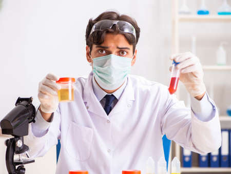Young handsome chemist working in the lab