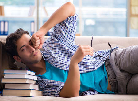 Tired student lying on the sofaの写真素材