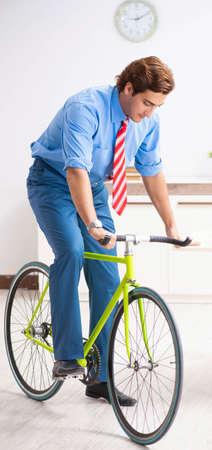 Young businessman using bike to commute to the officeの写真素材