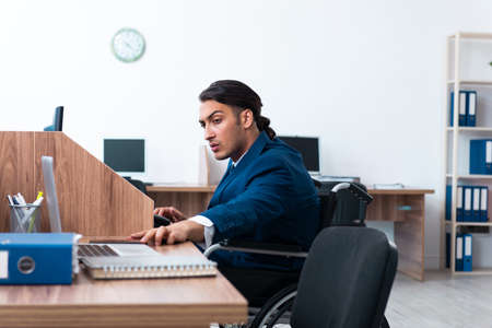 Young male employee in wheel-chairの写真素材