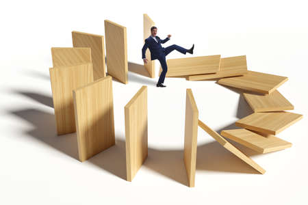 Businessman in domino effect conceptの写真素材