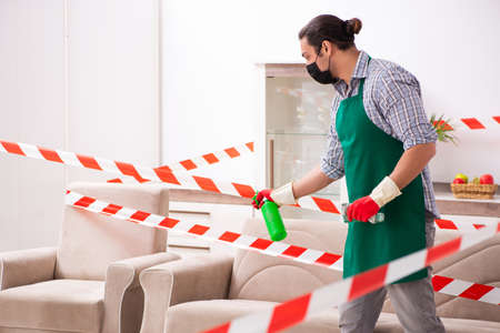 Young male sanitizer disinfecting indoorsの写真素材