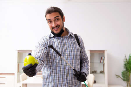 Young male sanitizer disinfecting indoorsの写真素材