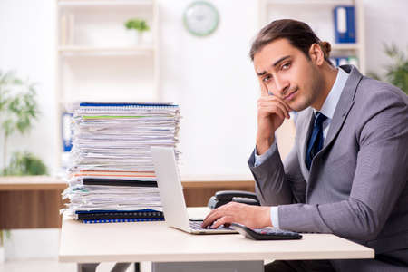 Young male businessman unhappy with excessive workの写真素材