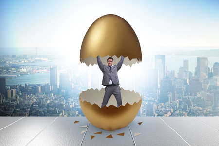Businessman breaking out of golden eggの写真素材