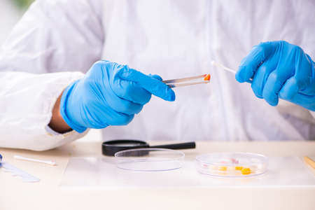Male expert criminologist working in the lab for evidence