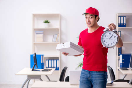 Young male courier delivering pizza to the office