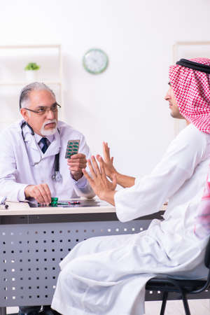Young male arab visiting experienced male doctorの写真素材