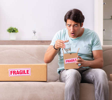 Man opening fragile parcel ordered from internetの写真素材