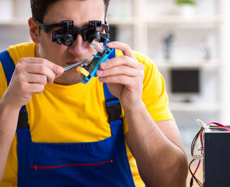 The computer repair technician repairing hardwareの写真素材