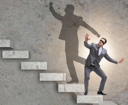 Businessman and his shadow in business conceptの写真素材