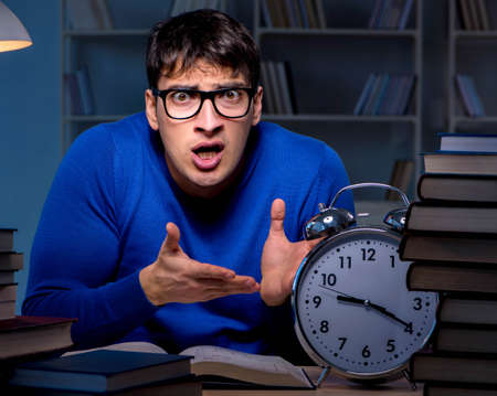 Student preparing for exams late at night in libraryの写真素材