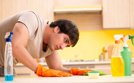 Single man cleaning kitchen at homeの写真素材