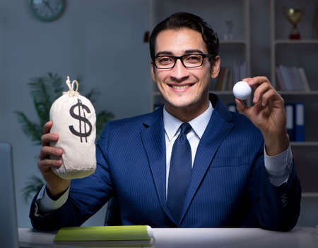 Young employee with golf ball in officeの写真素材