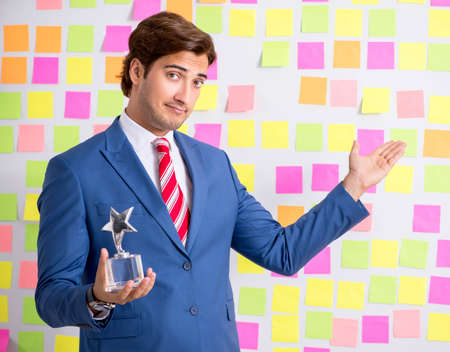 Young handsome man in conflicting priorities conceptの写真素材