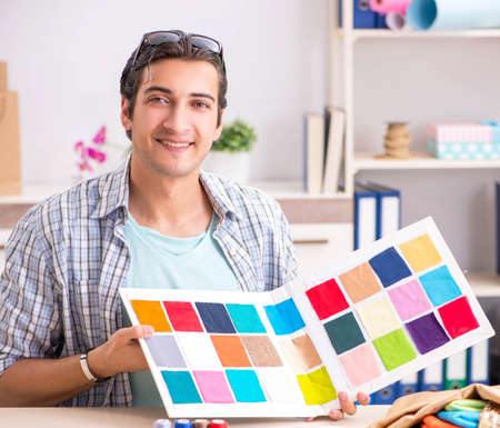 Young handsome tailor working in his workshopの写真素材