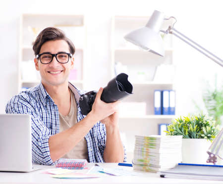 Young photographer working with his cameraの写真素材