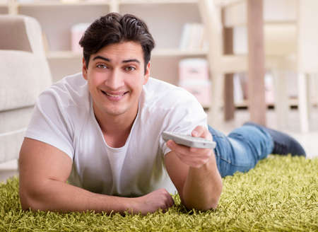 Man watching tv at home on floorの写真素材