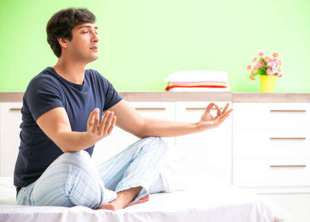 Young man in pajamas doing morning exercisesの写真素材