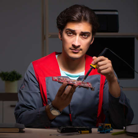 Young handsome repairman repairing computerの写真素材