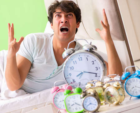 Young man having trouble waking up in early morningの写真素材