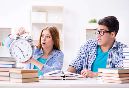 Two students runnng out of time to prepare for examsの写真素材