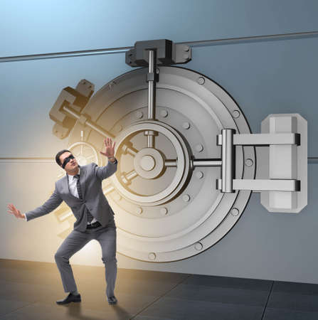 Businessman in front of banking vault doorの写真素材