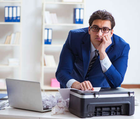 Businessman angry at copying machine jamming papers