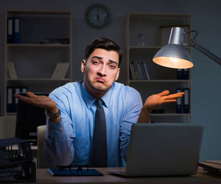 Employee working late at night at important reportの写真素材