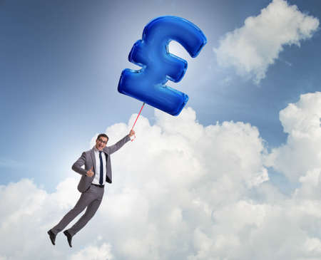 Businessman flying on british pound sign inflatable balloonの写真素材
