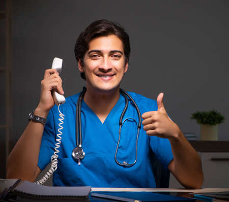 Young handsome doctor working night shift in hospitalの写真素材