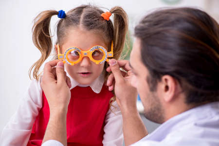 Small girl visiting young male doctor oculist