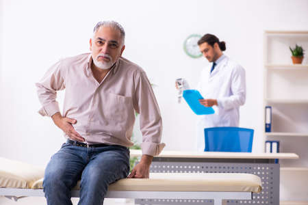 Old patient visiting young male doctorの写真素材