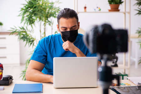 Young male doctor recording video for his blog