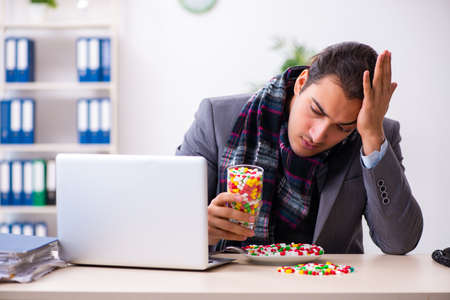 Young male employee suffering at workplaceの写真素材