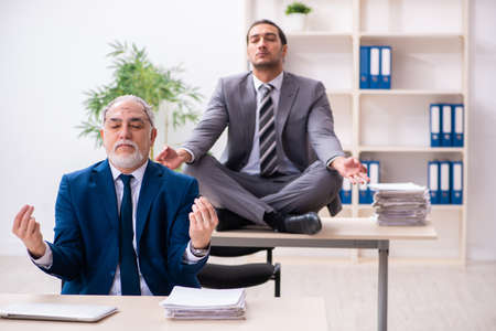 Two male employees working in the officeの写真素材