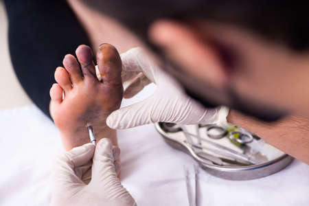 Finger injured woman visiting male doctor traumatologistの写真素材