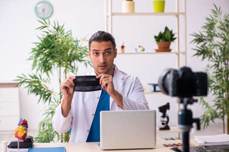 Young male doctor recording video for his blog